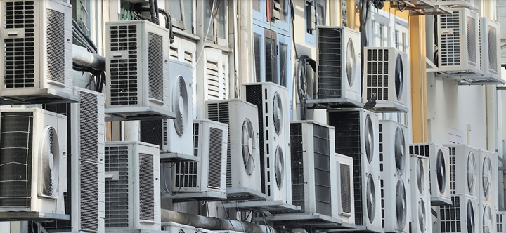 Many air conditioner units visible outside an apartment building in Singapore.