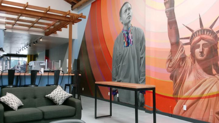 The interior of the 1951 Coffee Co. in Oakland, featuring a sofa, bar counter and large mural.
