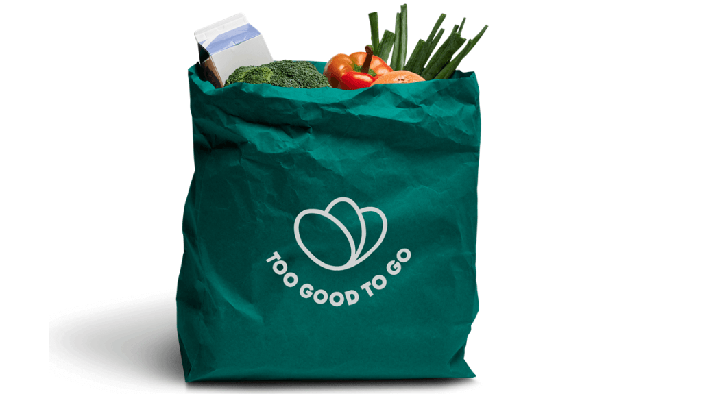A bag of saved food is pictured - the bag is green and features the logo and name of the food waste company, Too Good To Go.
