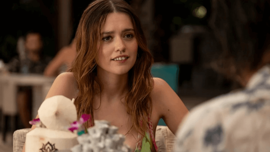 A screenshot of Chelsea (Aimee Lou Wood) having breakfast in a scene from The White Lotus, season 3.