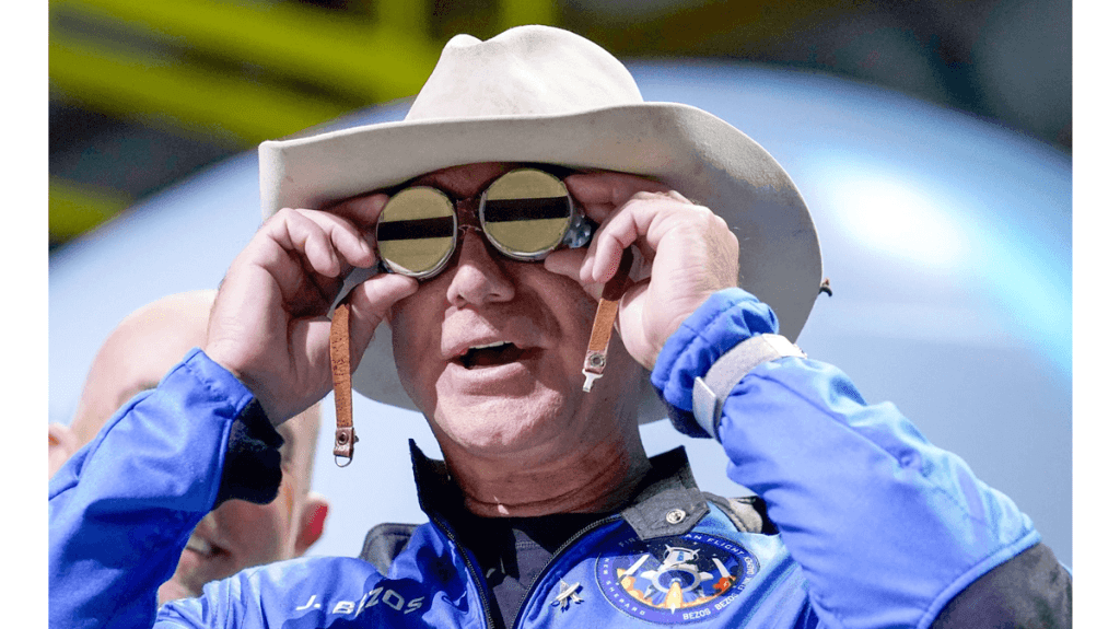 Jeff Bezos, CEO of Amazon.com, returns from a space flight wearing a blue suit and a cowboy hat. I the photo, Bezos is trying on goggles that belonged to aviator Amelia Earhart.  (Amazon withdraws support for older Kindles)